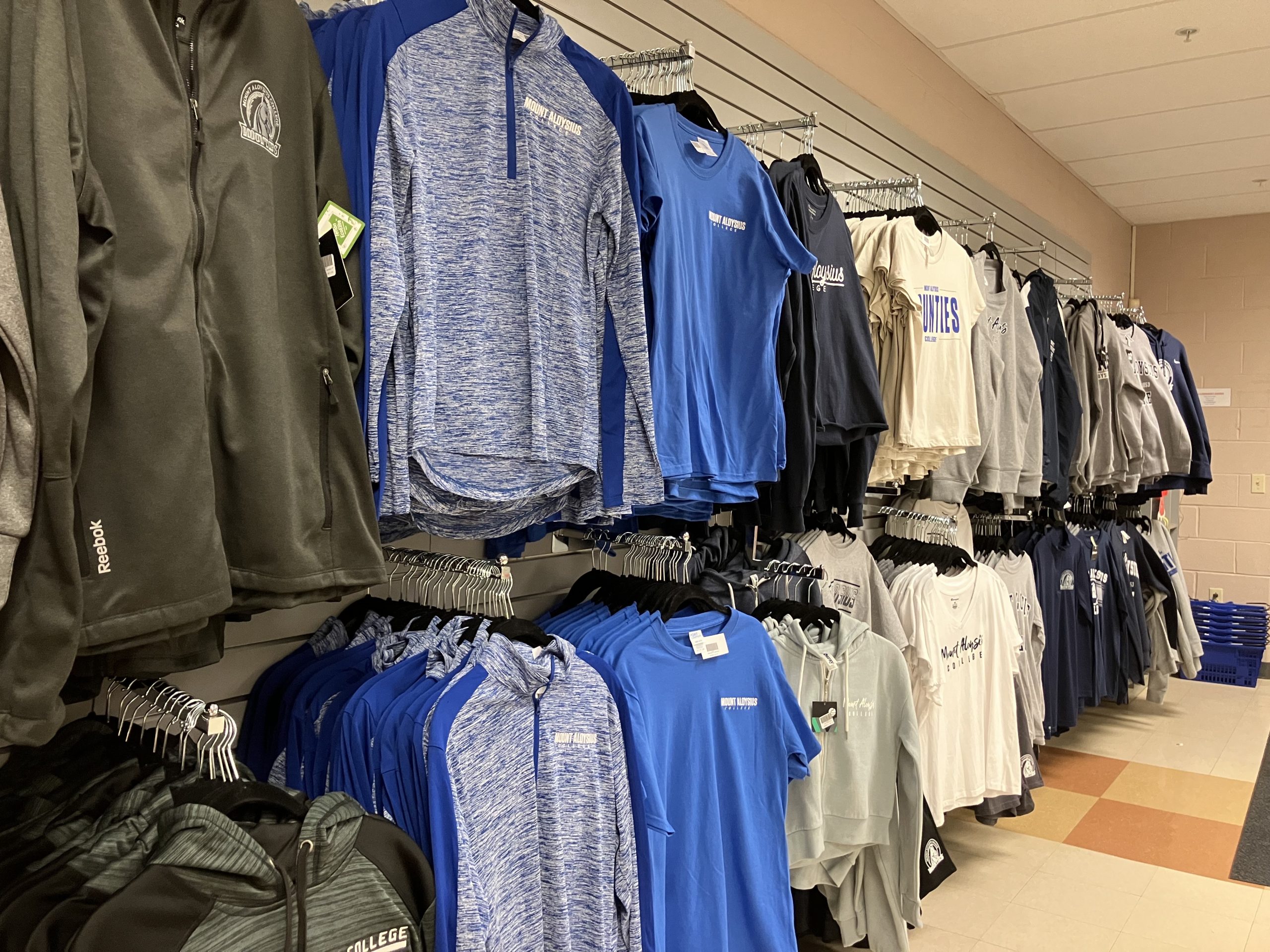 Bookstore Photo of Mount Aloysius College t-shirts hanging on the wall in the Bookstore.