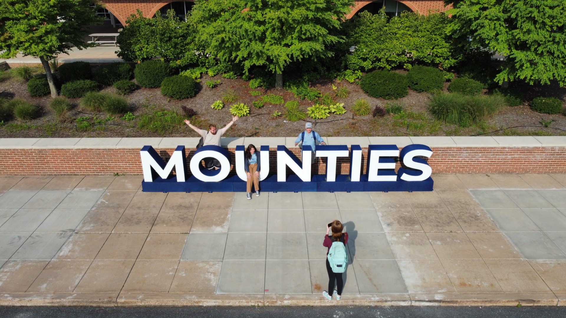 dji_fly_20220915_095214_454_1663337201227_photo_optimized (Large) aerial picture of students at the Mounties sign