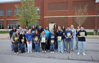 18 Mount Aloysius students stand together outside of the College's ACWC. They are holding the books that will be recorded during Operation Storybook.